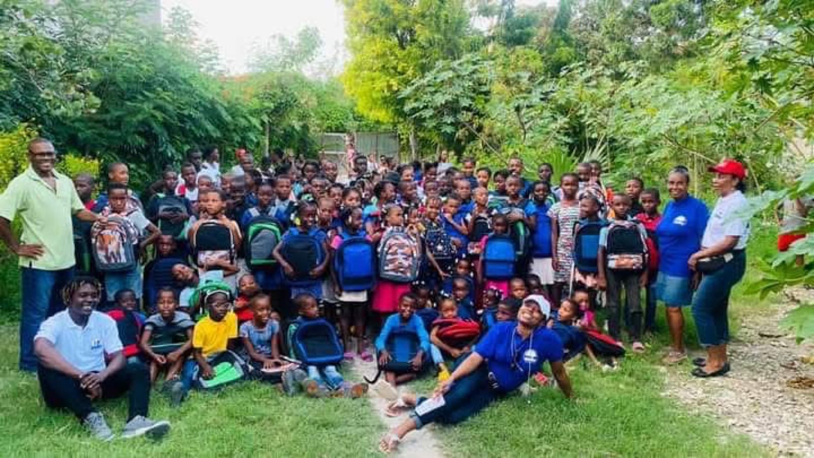 Children holding new backpacks and school supplies